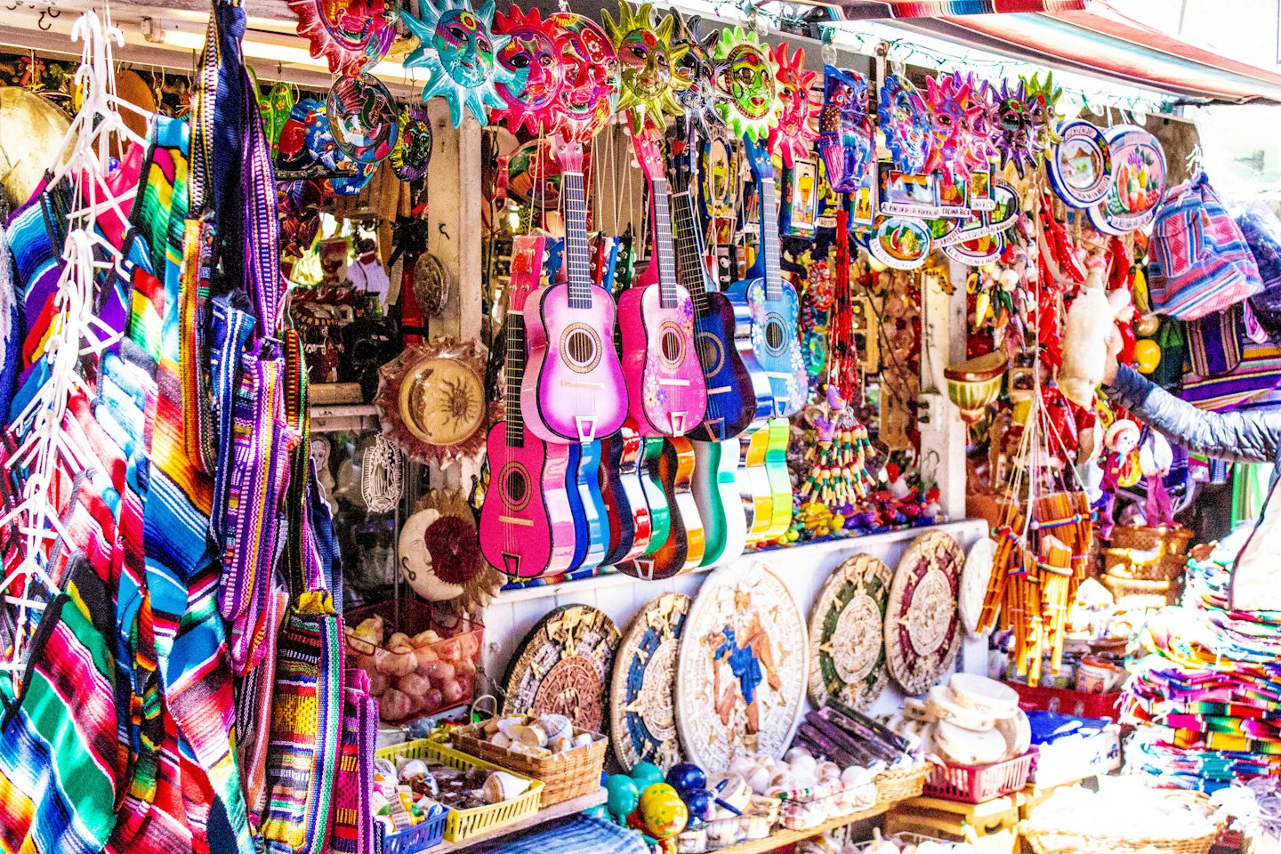 Hand reaching for colorful handcrafted goods at an outdoor market.